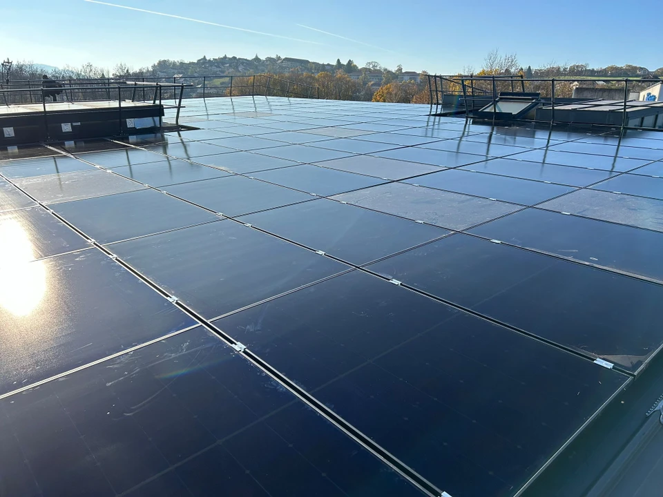 Extérieur, technicien avec gants noirs nettoie panneau solaire photovoltaïque avec jet d'eau haute pression